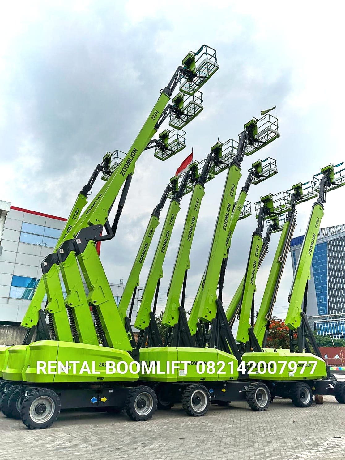 Deretan boom lift Zoomlion hijau dengan lengan teleskopik yang menjulang tinggi ke langit.